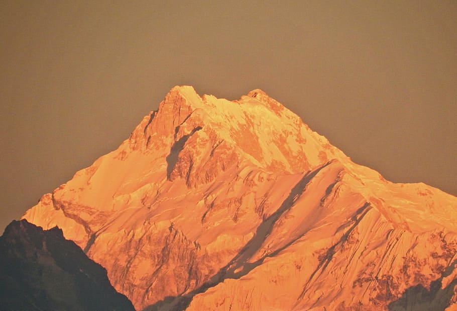 Kanchenjunga Peak, mountain alps with snow, orange, shadow, rock