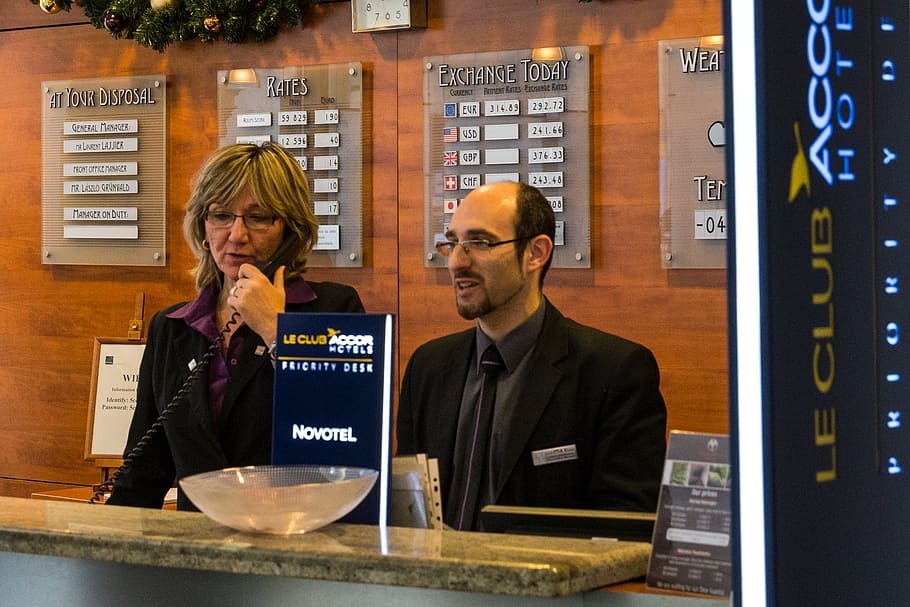 man and woman standing in front of LE Club front desk, reception HD wallpaper