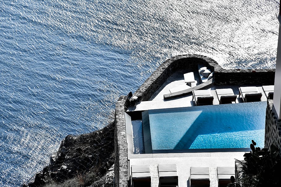 gray and white concrete building over body of water, white and blue building near body of water during daytime HD wallpaper