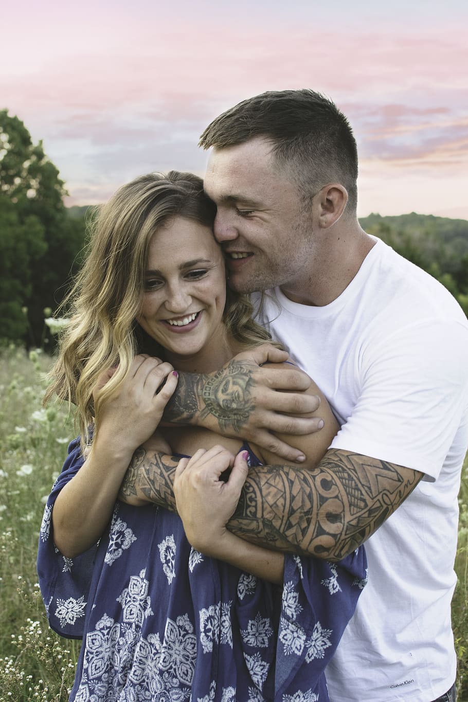 man hugging woman in grass field at daytime, tattoos, love HD wallpaper