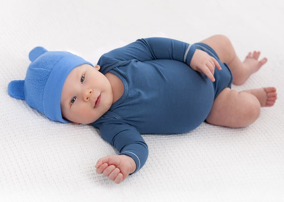 baby wearing blue onesie lying on cushion, boy, newborn, child