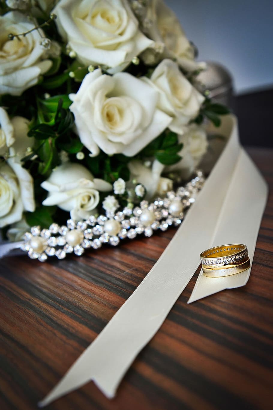 gold-colored clear gemstone encrusted ring on white ribbon near bouquet of white roses HD wallpaper