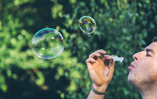 man playing bubbles, person blowing bubbles, soap Sud, outdoors HD wallpaper