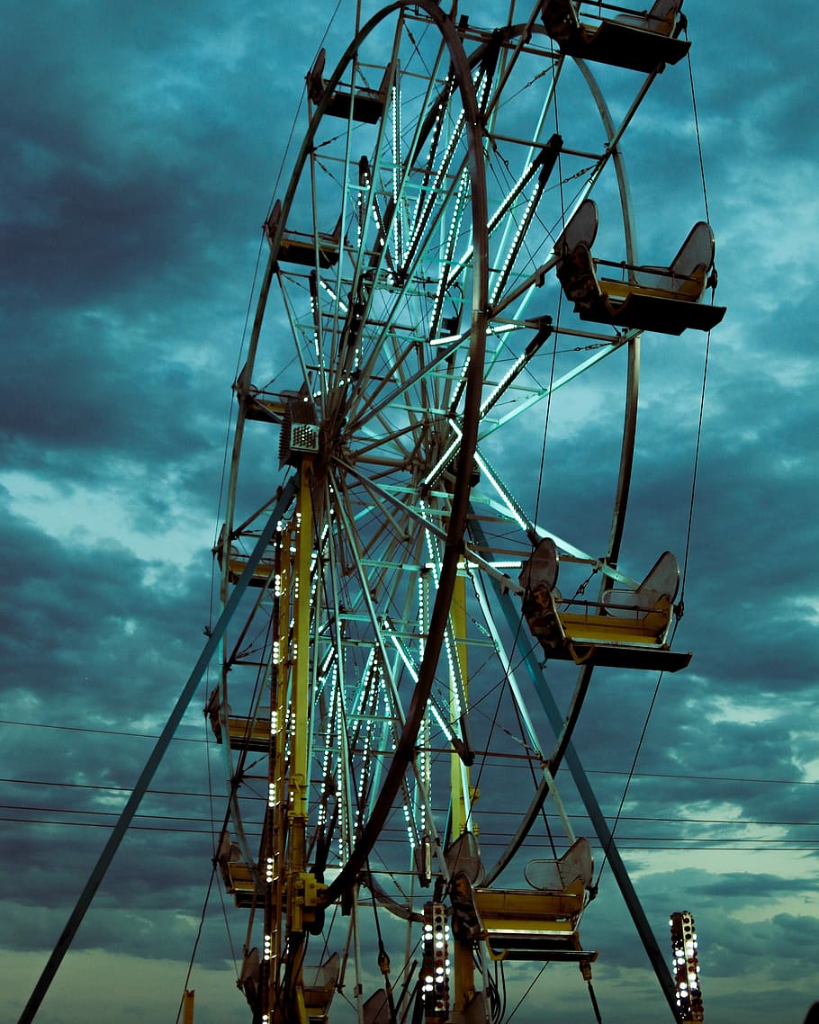 close up photography of ferris wheel under cloudy sky, gray and yellow fairestwheel