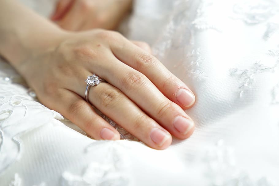 person wearing silver-colored clear gemstone ring, bride, hand