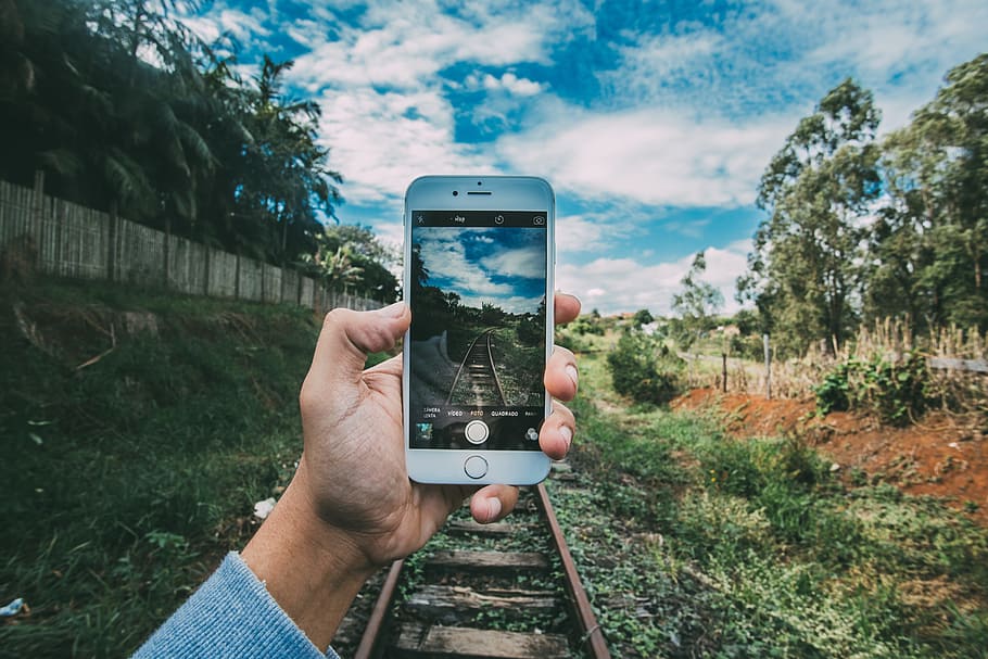 person taking photo of train rail during daytime, grass, hand HD wallpaper
