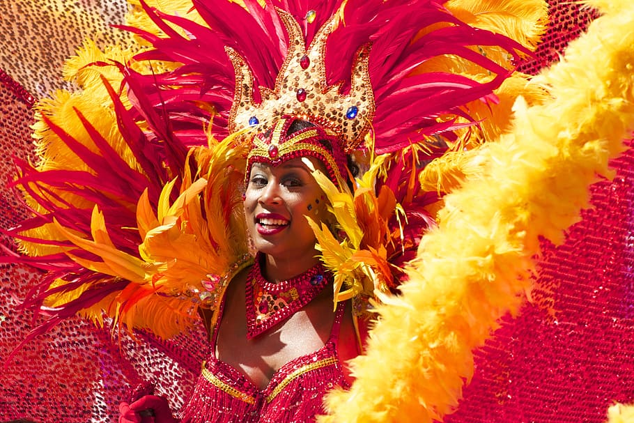 woman wearing red and yellow costume smiling, carnival, orange