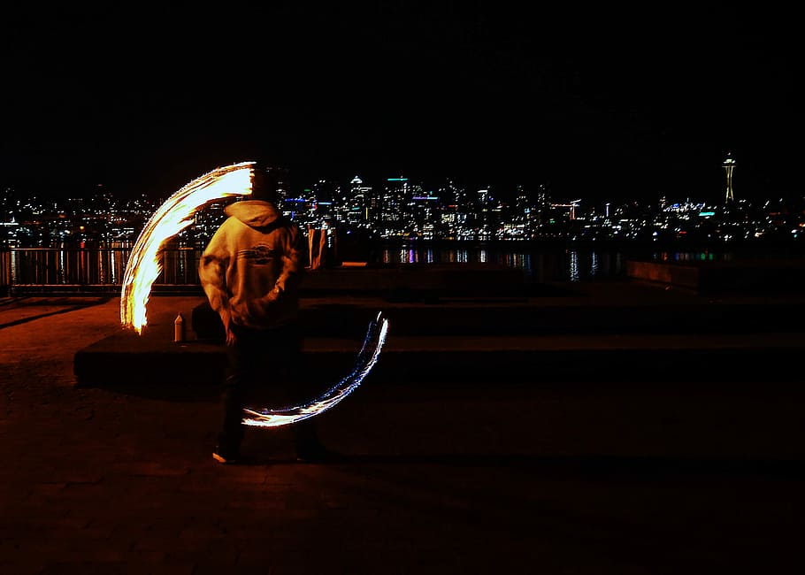 man doing fire dance during nighttime, fire show, park, city light HD wallpaper