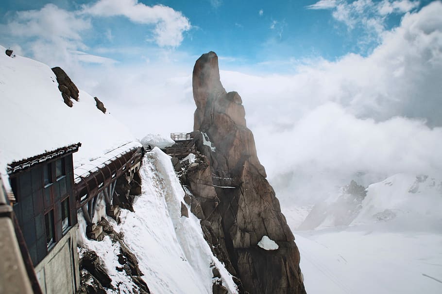snow filled mountain with train railway, building near cliff under cloudy sky HD wallpaper