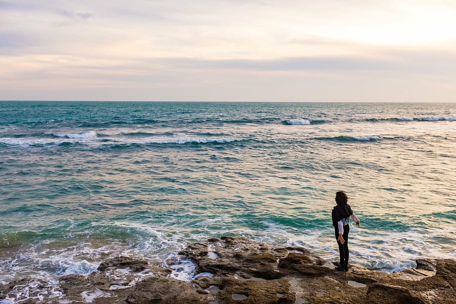 person standing near ocean water, rock, beside, beach, rocks HD wallpaper