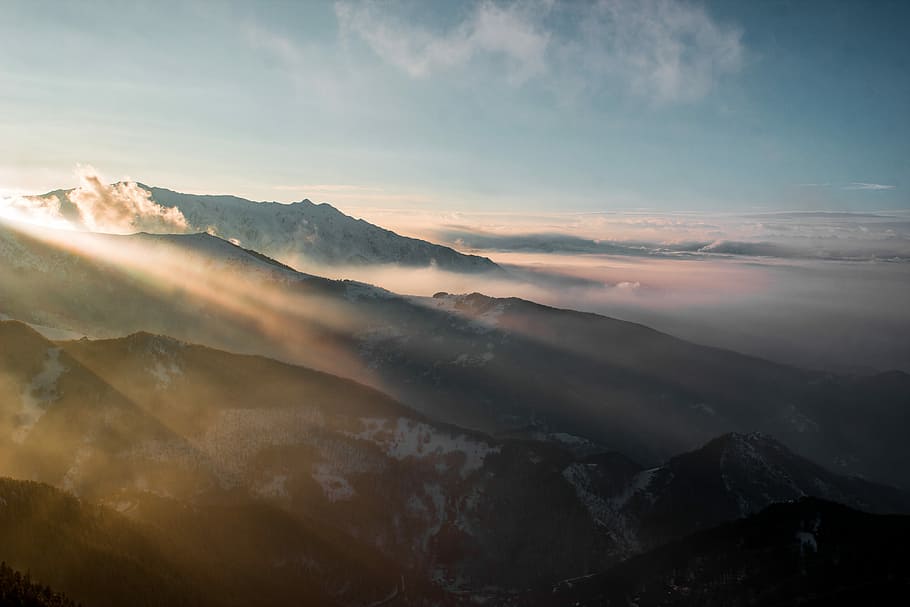 mountains covered with clouds, aerial photography of mountain covered with snow under white and blue cloudy skies HD wallpaper