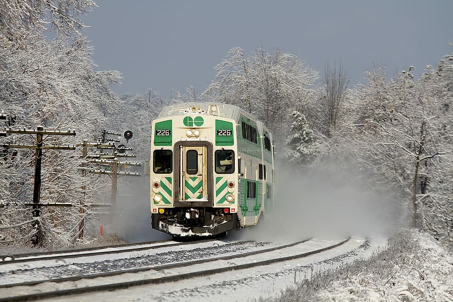 white and green train on railway during daytime, green and white train traveling near snow covered trees HD wallpaper
