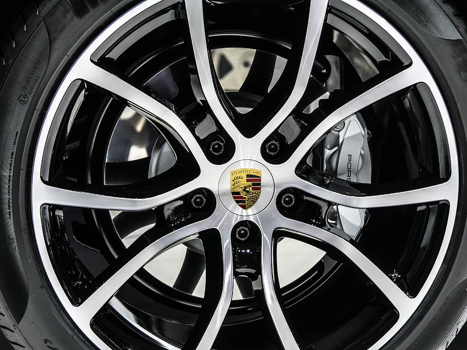 gray Porsche 5-spoke vehicle wheel and tire in close-up photo