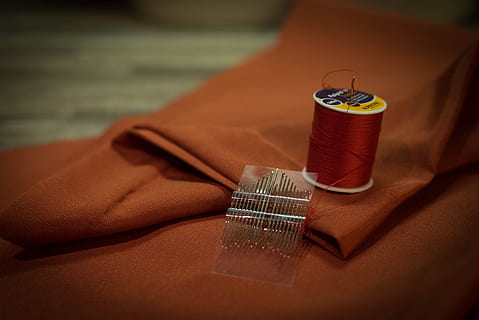 thread spool beside needles on textile, fabric, sewing, needlework HD wallpaper