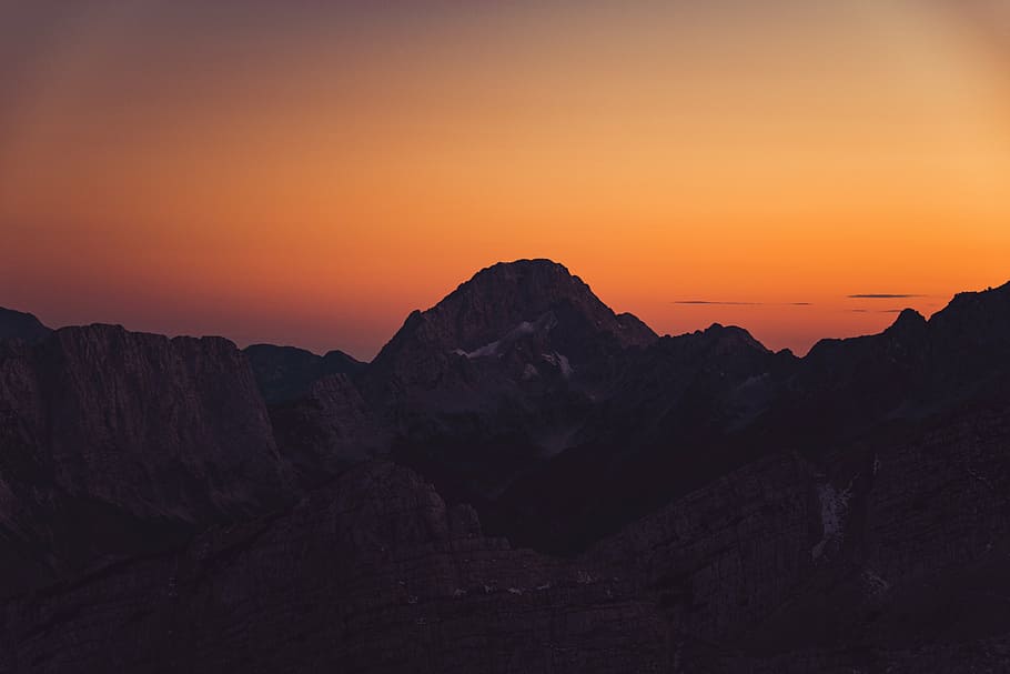 black mountain range with sunlight glaring on rocks, silhouette HD wallpaper