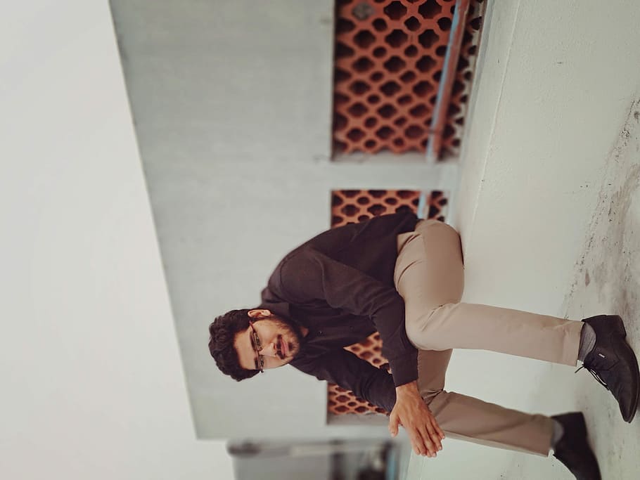 man in black dress shirt sitting on white concrete, real people HD wallpaper
