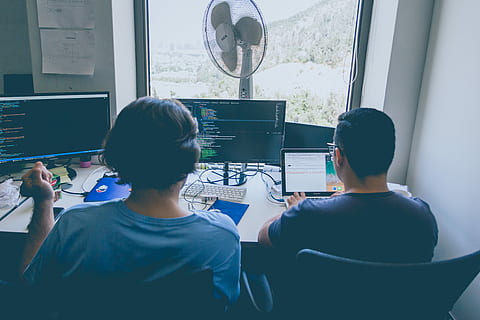 two men using computer and laptop, two people sitting in front of two computer monitors HD wallpaper