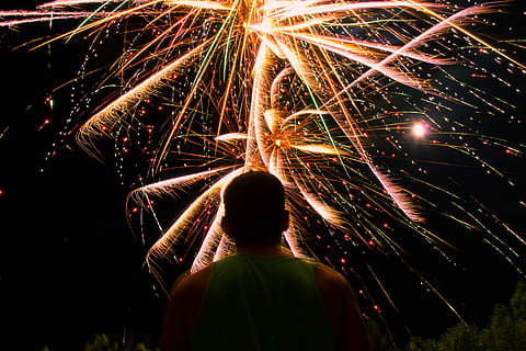man watching over firework display during nighttime, man standing facing upward looking fireworks HD wallpaper