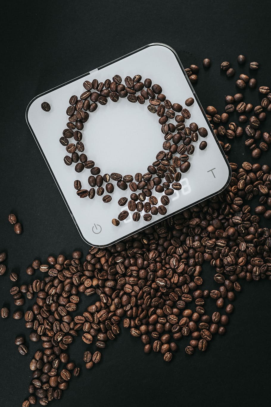 coffee beans on top of white cube scale in closeup photography, coffee beans