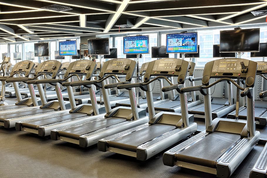 gray treadmill lot, gym, fitness, indoors, no people, in a row