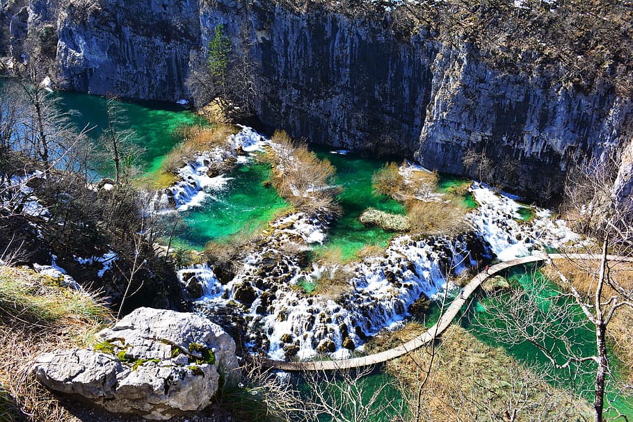 aerial photo of bridge near rock formation, aerial photography of body of water surround by rocks during daytime HD wallpaper
