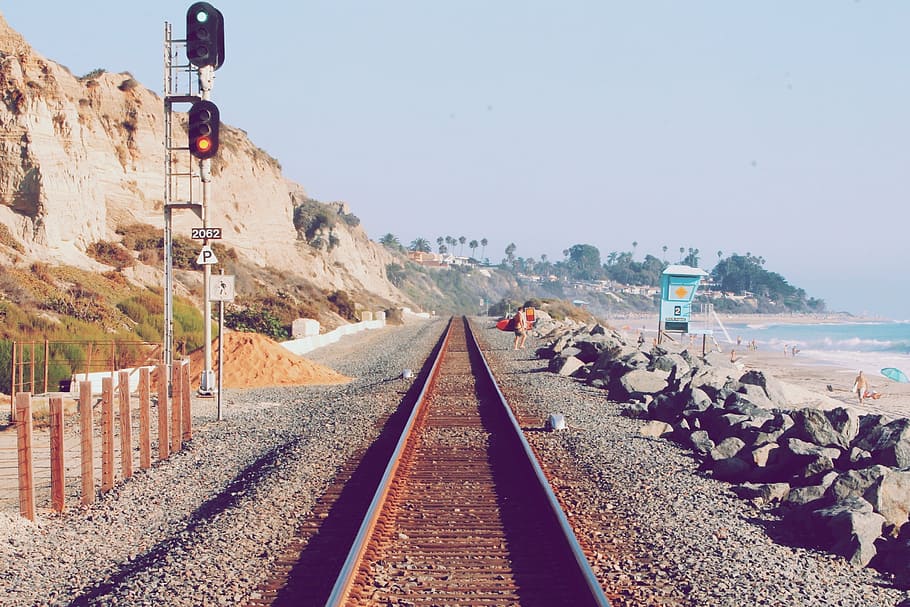 train railway near seashore, man, standing, daytime, train tracks HD wallpaper