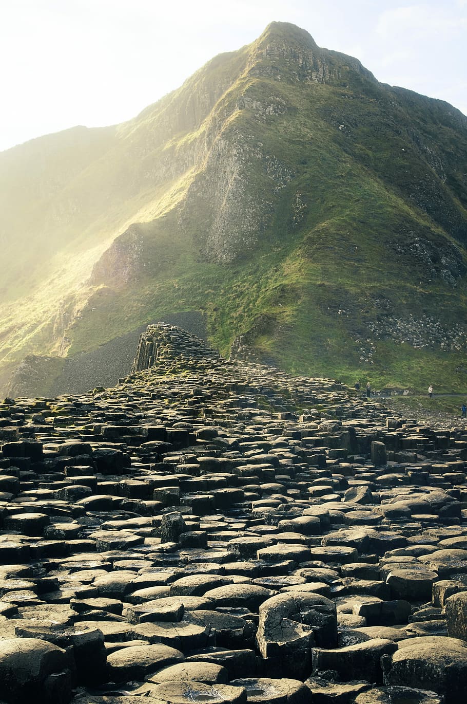 pile of rocks near on mountain, green mountain during daytime HD wallpaper