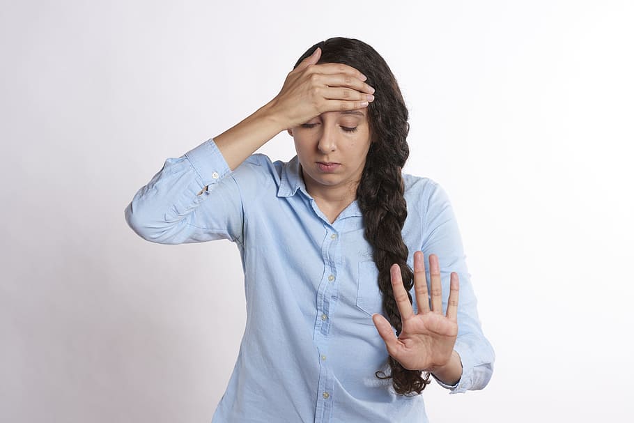 woman wearing blue dress shirt stopping gesture, upset, overwhelmed