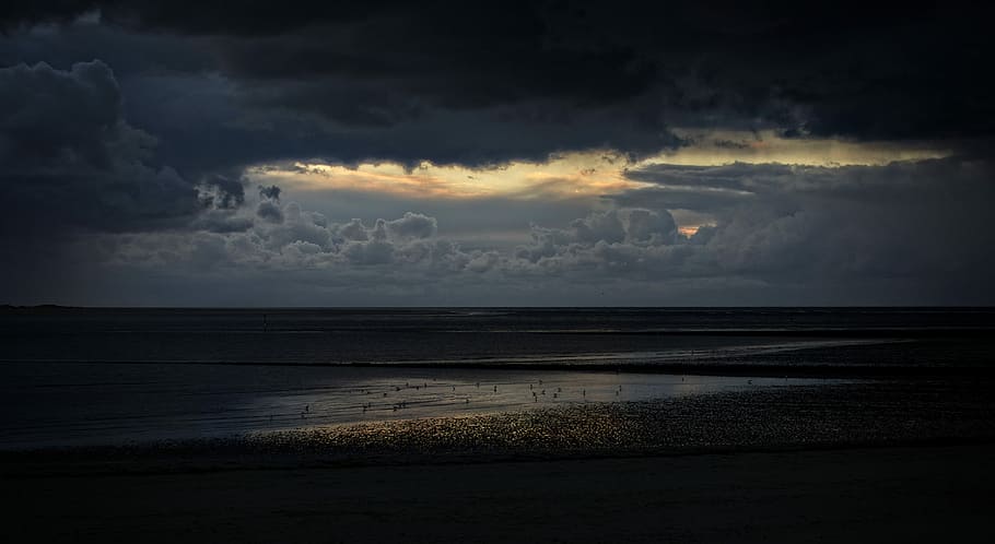 landscape photography of seashore during cloudy day, nimbus cloud over body of water HD wallpaper