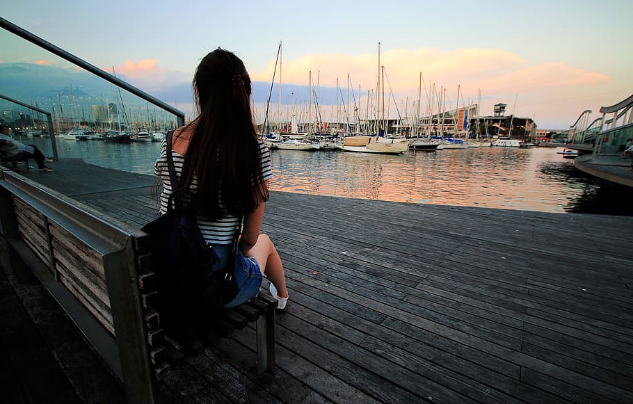 Woman in Black and White Stripe Scoop Neck Shirt Sitting on Brown Wooden Bench in Ship Dock during Daytime HD wallpaper