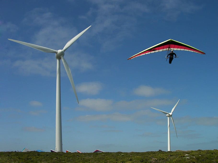 man riding on kite and view of two wind turbines, Hang Glider