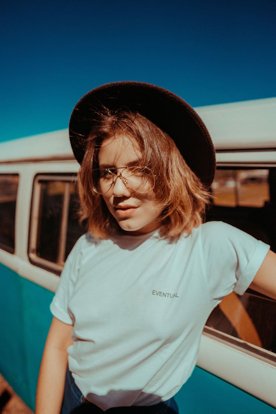 woman posing for photo beside van during daytime, woman wearing white crew-neck t-shirt HD wallpaper