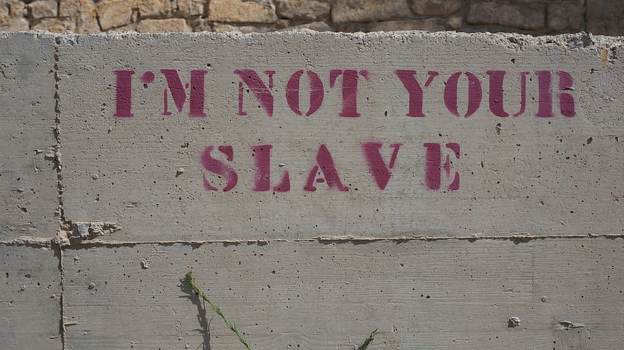 I'm Not Your Slave text on gray concrete wall, saying, graffiti