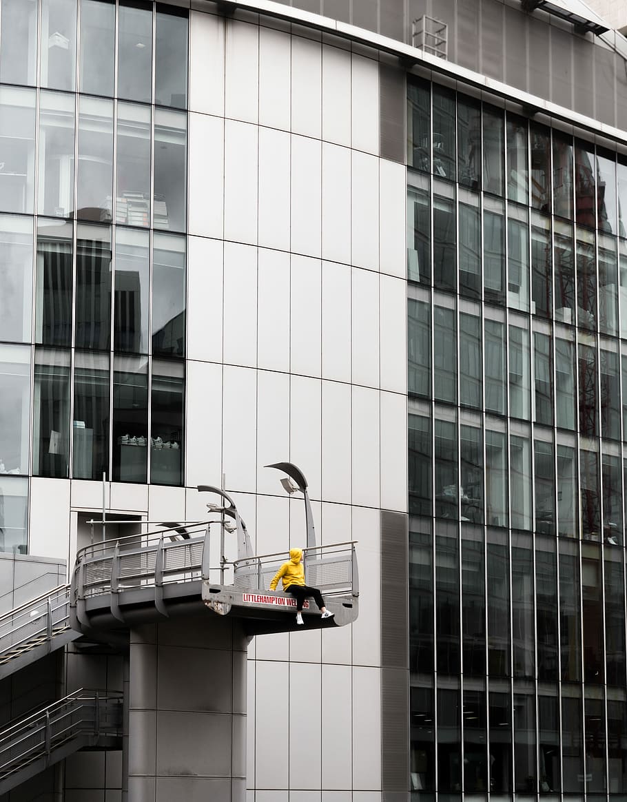 person sitting on edge of bridge near building during daytime, person sitting on stairs HD wallpaper