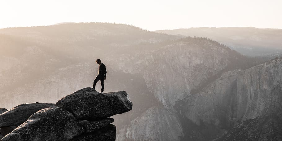 man standing on top of mountain during daytime, landscape photography of man on mountain HD wallpaper