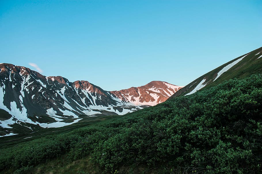 green mountain range under clear sky, landscape photograph of mountain ranges covered with snow HD wallpaper