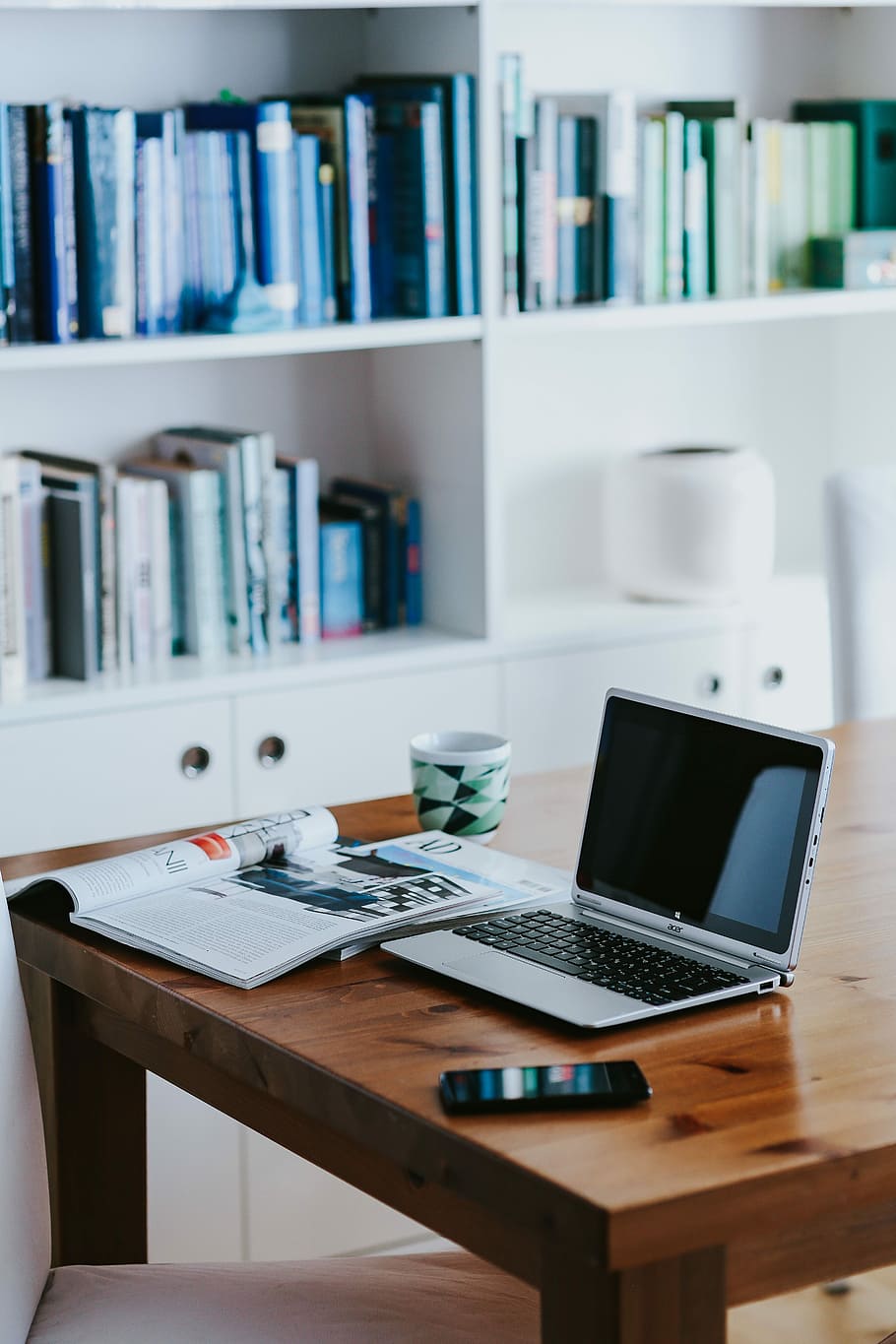 Silver laptop with various items on a table, magazines, computer HD wallpaper