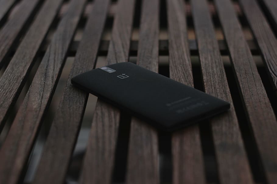 black OnePlus 1 smartphone on brown surface, technology, communication HD wallpaper