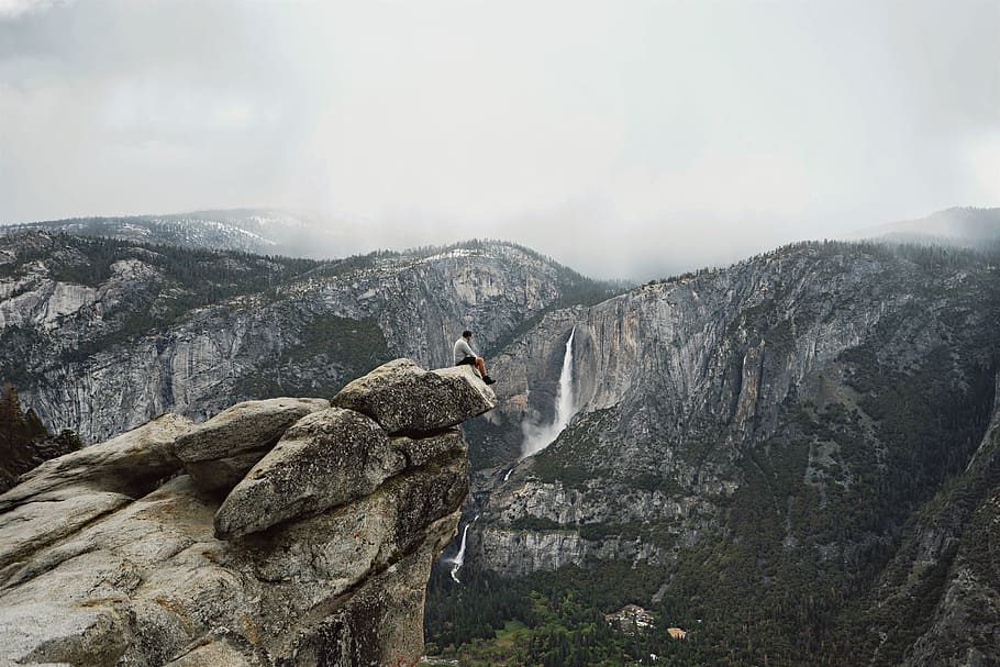 man sitting on cliff, mountain, trees, forest, nature, plants HD wallpaper