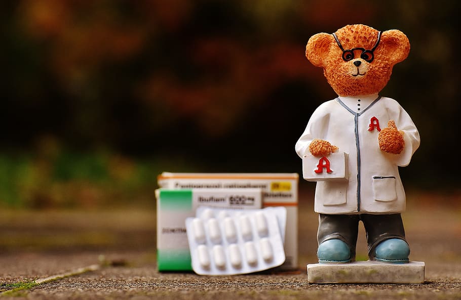 shallow focus photography of brown bear figurine on gray pavement HD wallpaper