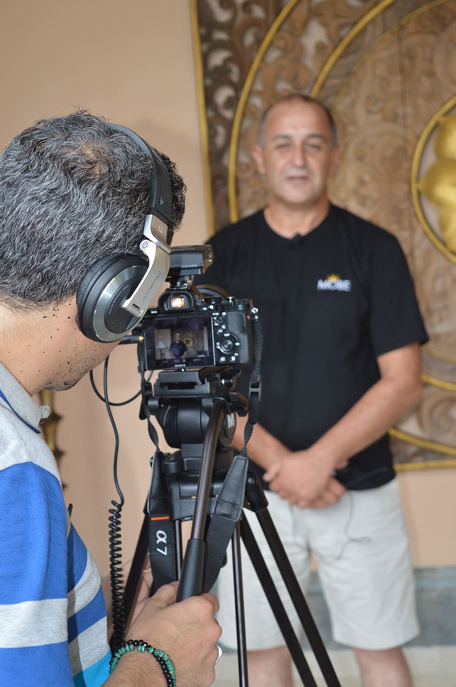 man standing beside wall near camera, interview, meeting, businessman HD wallpaper