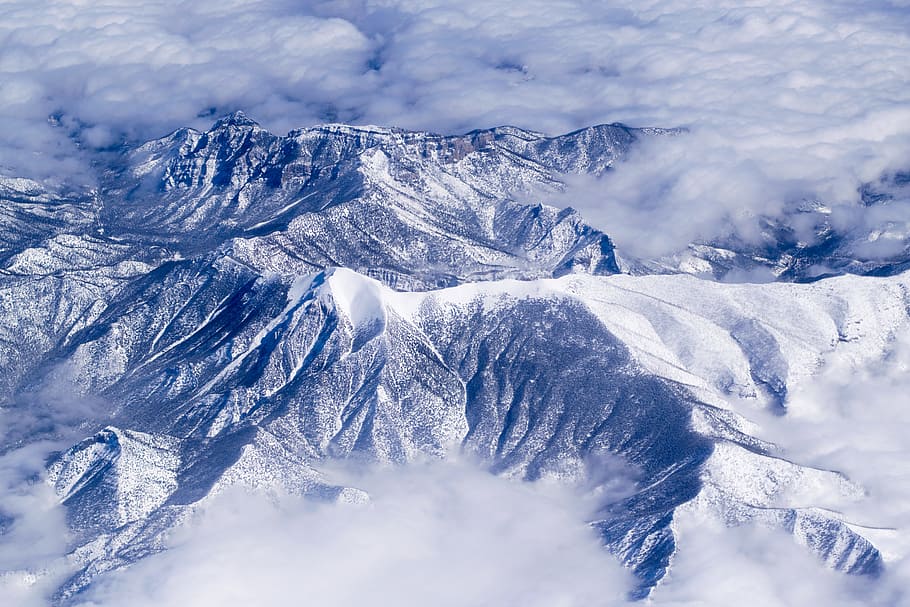 aerial view of snow covered mountains, photo of mountain during winter season