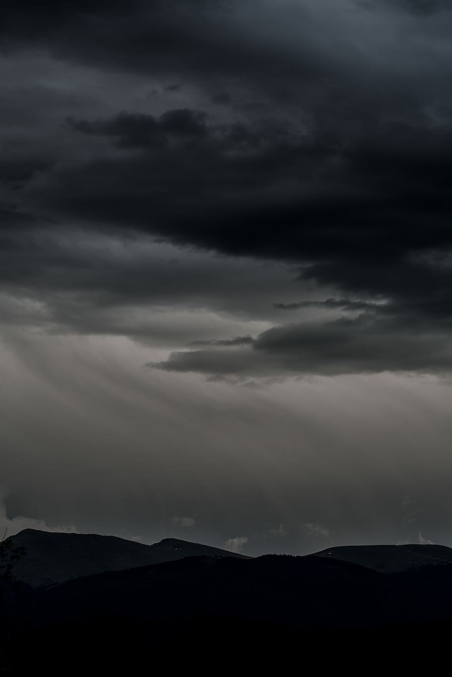 silhouette of mountain under dramatic sky, photography of mountain under black clouds HD wallpaper