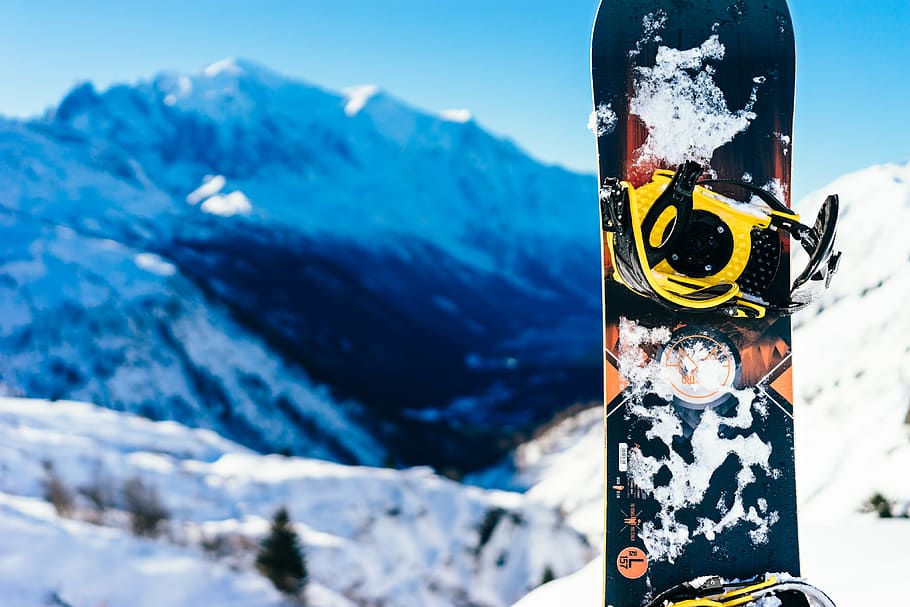 shallow focus photography of snowboard, black, yellow, and orange snowboard HD wallpaper