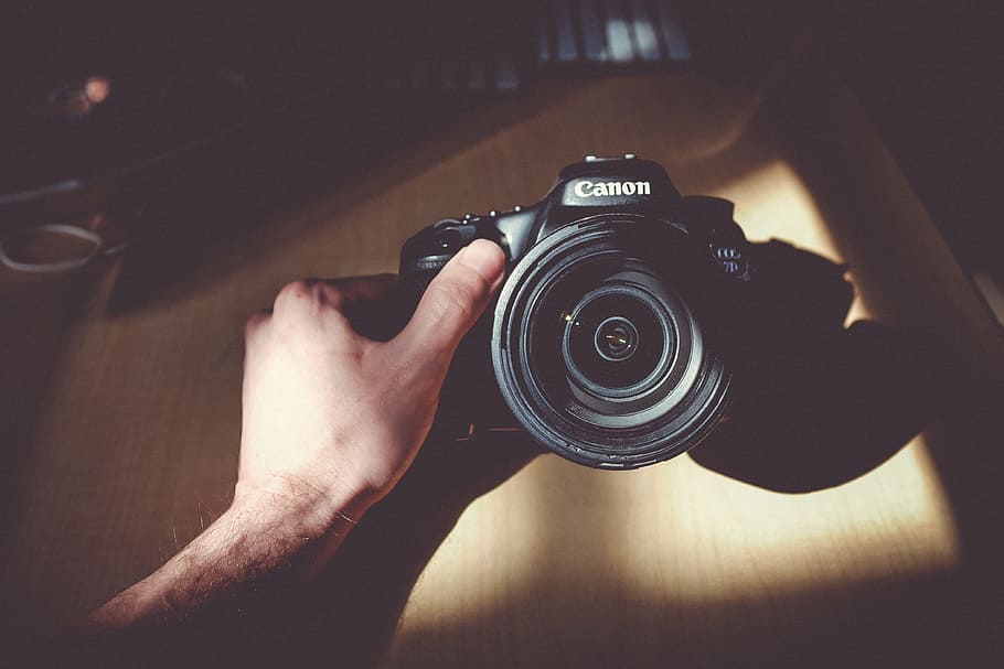 person holding Canon DSLR camera, black, canon camera, lens, hand HD wallpaper