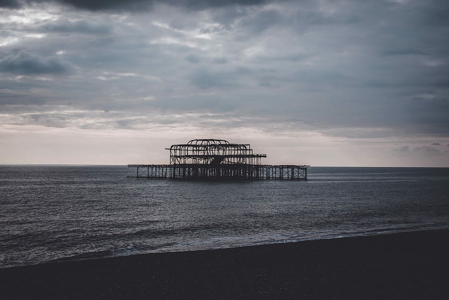 brown steel frame, seashore under cloudy sky, structure over water HD wallpaper