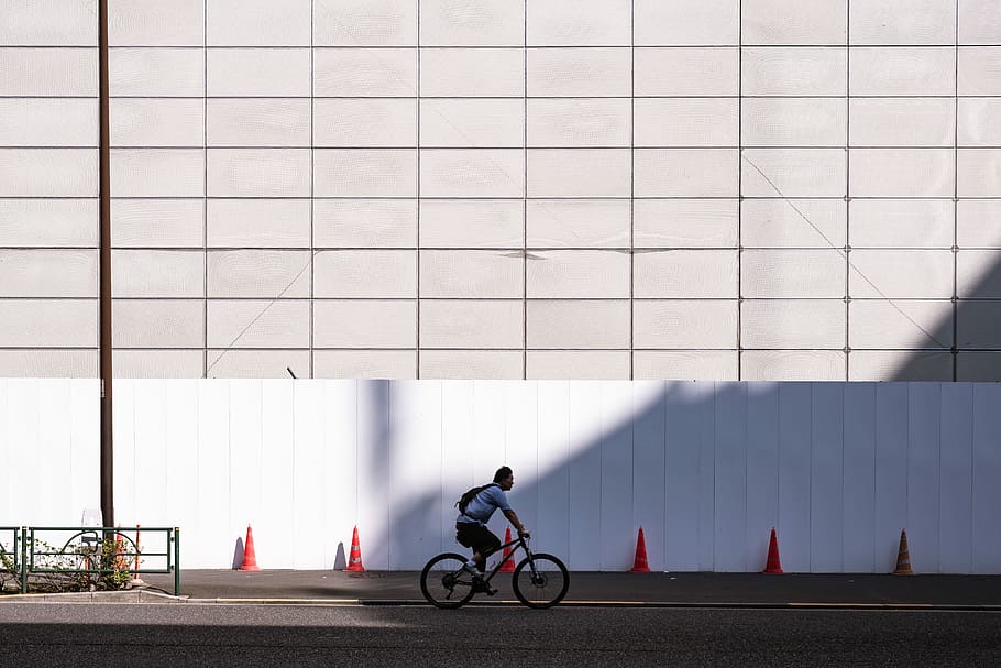 man riding bicycle near white wall during daytime, man riding bicycle on road HD wallpaper