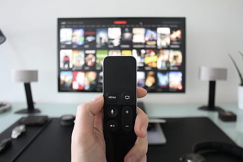 Man using Apple Television with remote control for movies, technology HD wallpaper