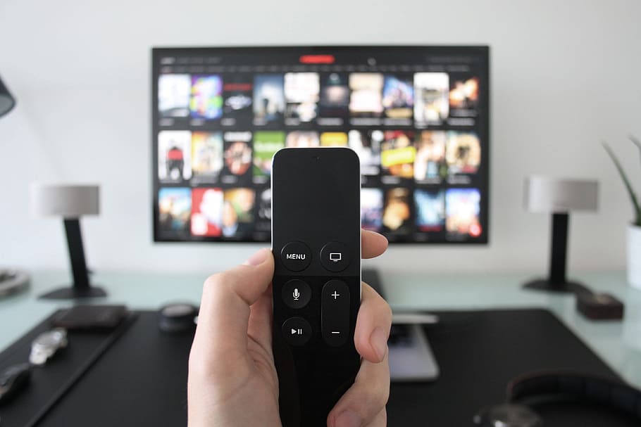 Man using Apple Television with remote control for movies, technology, HD wallpaper