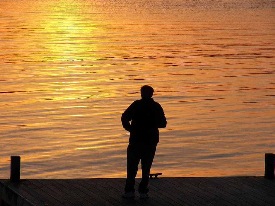 silhouette photography of person standing in front of body of water HD wallpaper